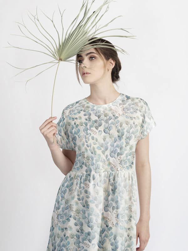 modelo en vestido con estampado con motivo de hojas de acuarela en color azul